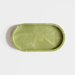A versatile sage green marbled jesmonite oval tray for jewellery, candles, bathroom or desk accessories. Handmade by Klndra for Curious Makers.