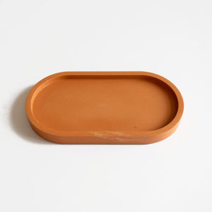  A jesmonite oval tray in a warm terracotta hue handmade by Klndra for Curious Makers