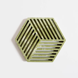A contemporary sage green jesmonite hexagonal trivet with a subtle marbled finish by Klndra for Curious Makers