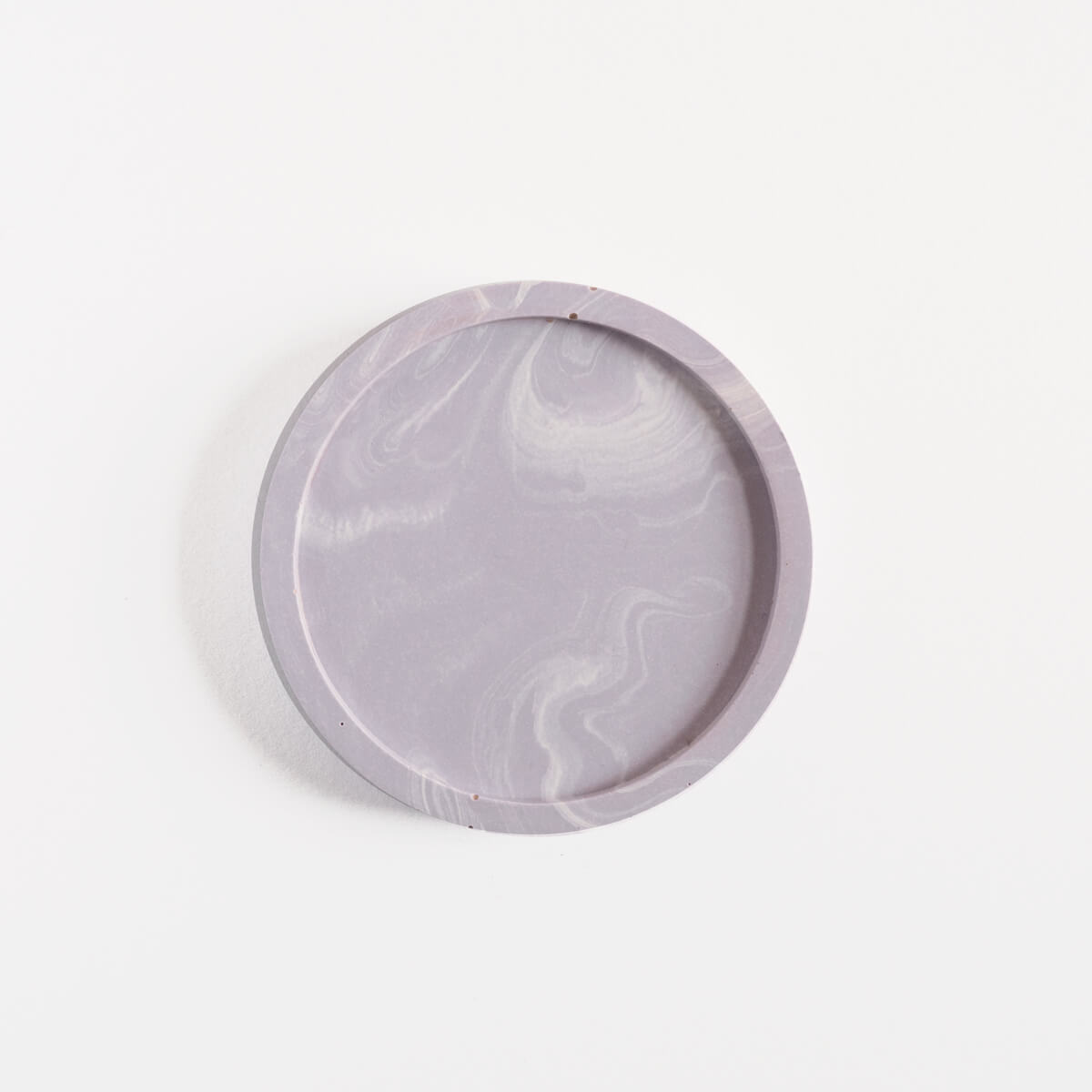 A single marbled lilac round coaster handmade by Klndra for Curious Makers