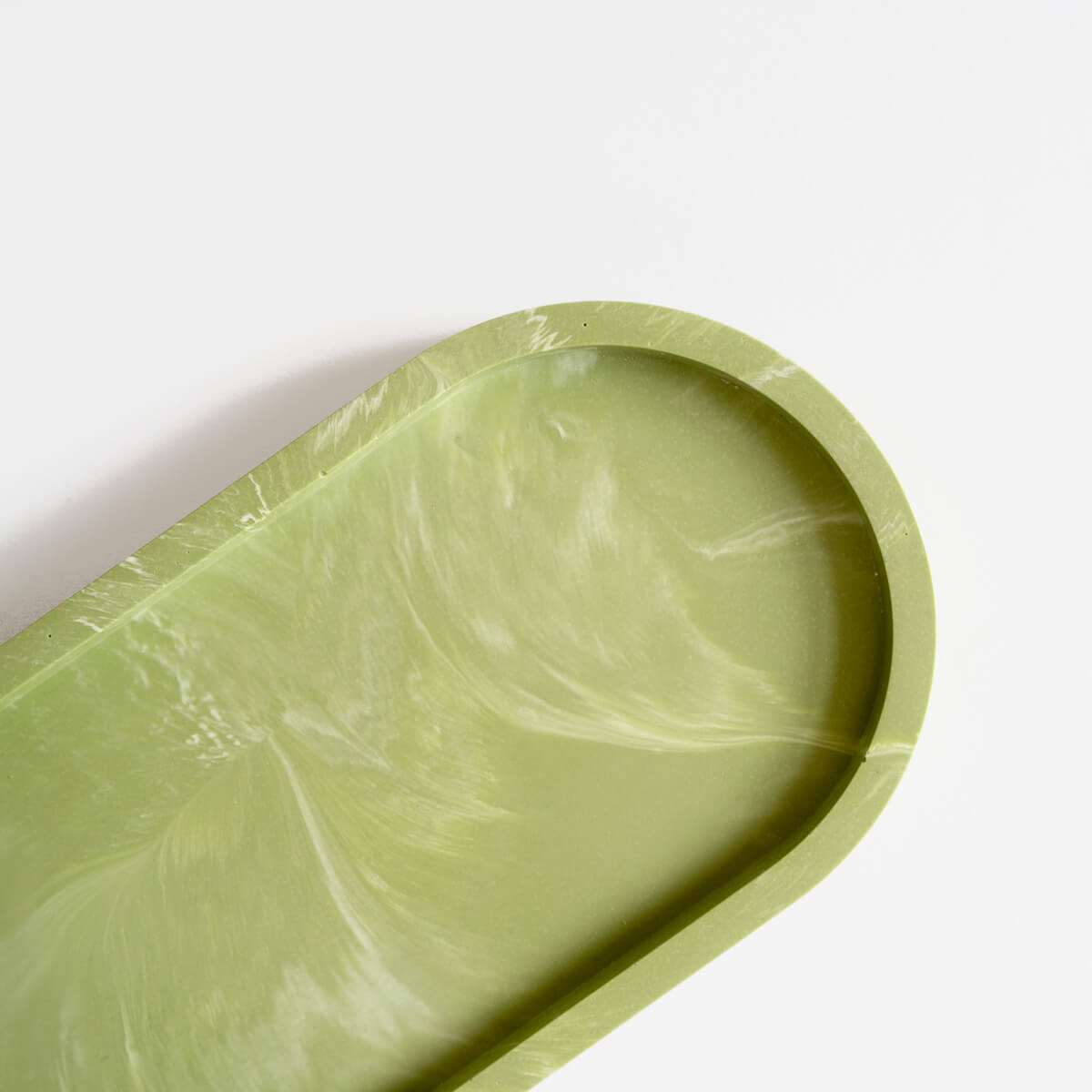 Close up of a marbled sage green jesmonite oval tray handmade by Klndra for Curious Makers