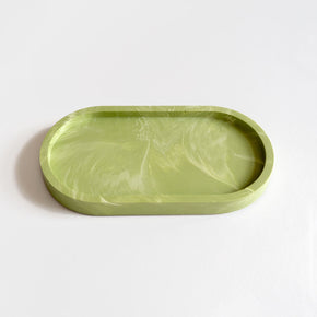 A versatile sage green marbled jesmonite oval tray for jewellery, candles, bathroom or desk accessories. Handmade by Klndra for Curious Makers.
