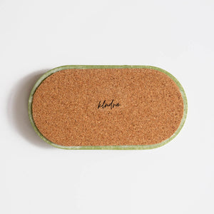The back of a marbled sage green jesmonite tray by Klndra for Curious Makers showing the cork base to protect surfaces.