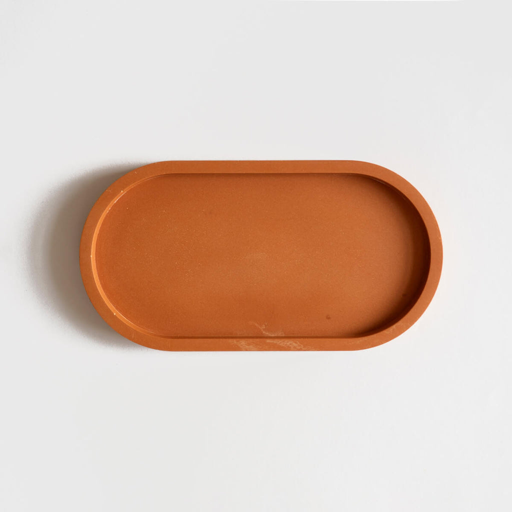  A jesmonite oval tray in a warm terracotta hue handmade by Klndra for Curious Makers