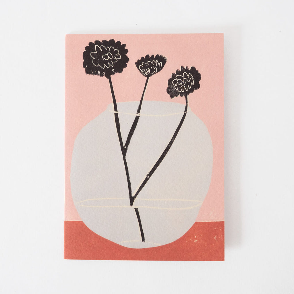Greeting card of still life of three flowers in a wonky vase.