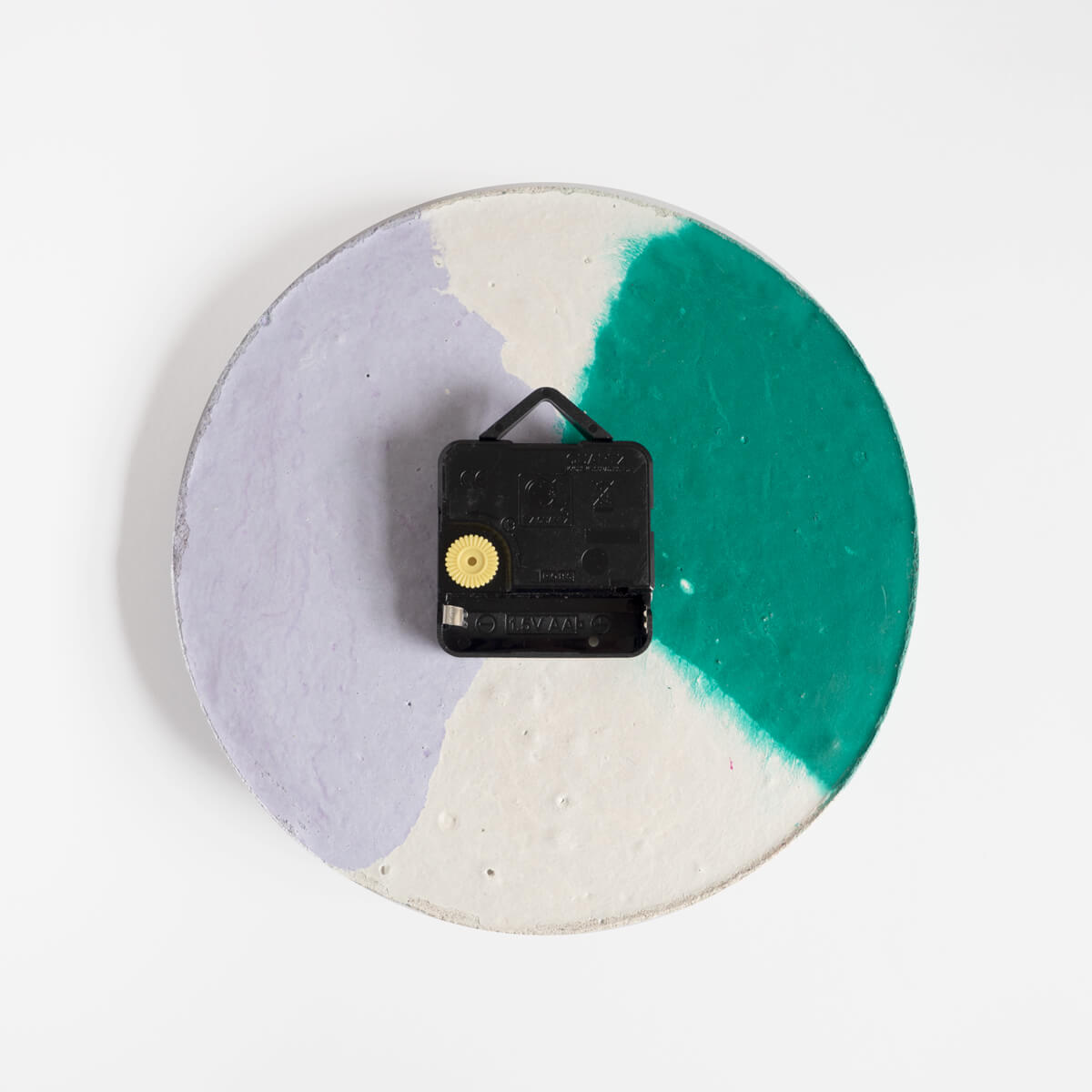 The back of a round concrete wall clock by Studio Emma for Curious Makers