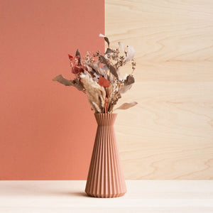 Sculptural 3d printed vase in an earthy terracotta colour with dried flowers